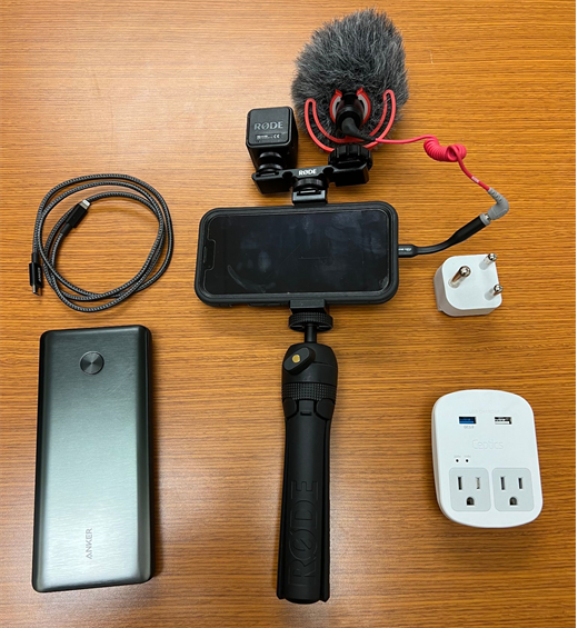 a cellphone on a gimbal with a microphone and light attachments.