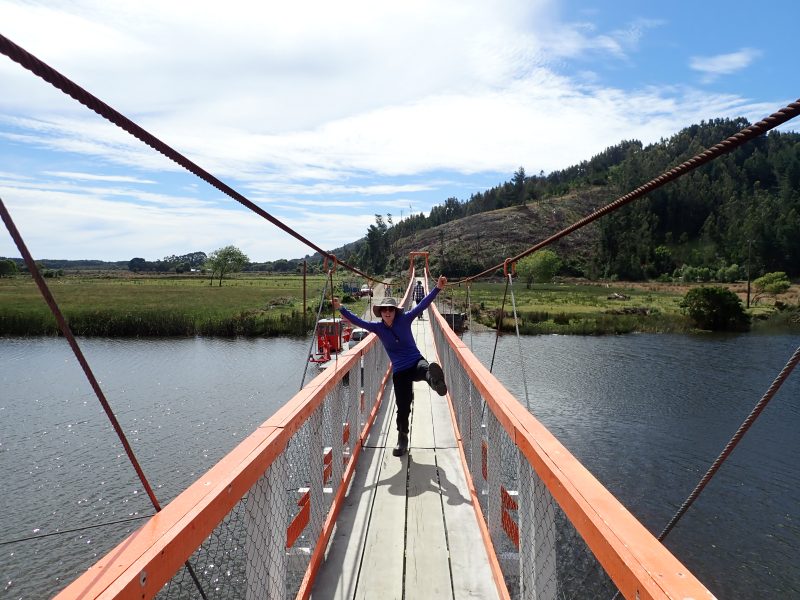 Person stands in a silly manner on a narrow bridge